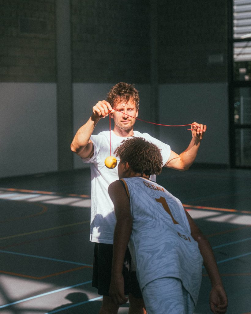 Coach moedigt een deelnemer aan tijdens een oefening in de sporthal – resilience