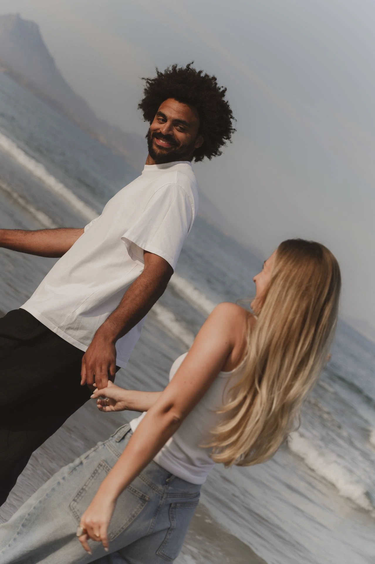Founders Jean-Marc Mwema en Mirte Rens lachen samen aan zee