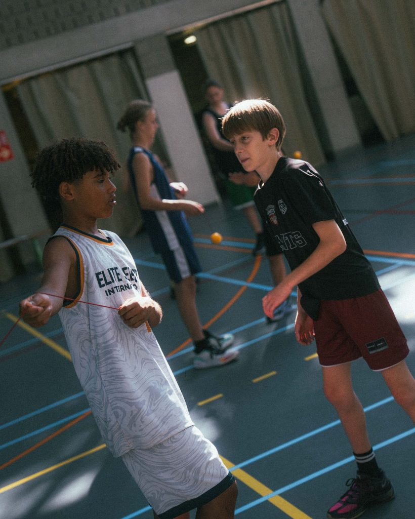 Jongeren spelen basketbal tijdens IMPACT [Camp]