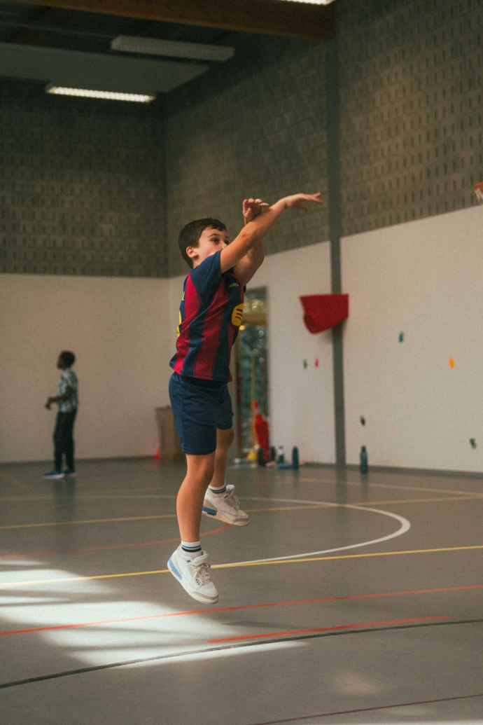 Speler neemt een schot in de sporthal tijdens IMPACT [Camp]